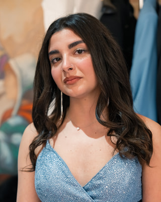 Una ragazza sorridente con un abito azzurro con le paillettes, in un negozio di abiti.