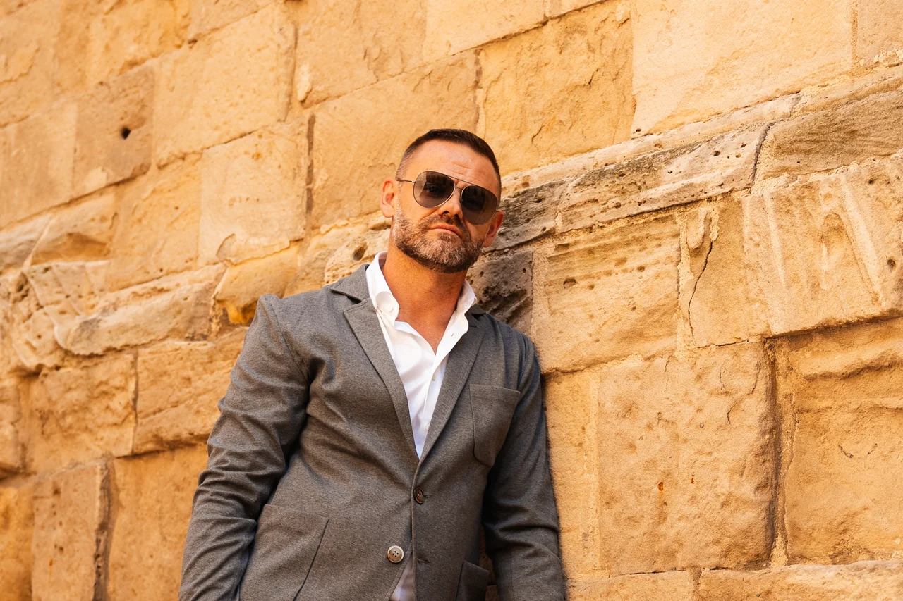 Ritratto di moda appoggiato a un muro di pietra