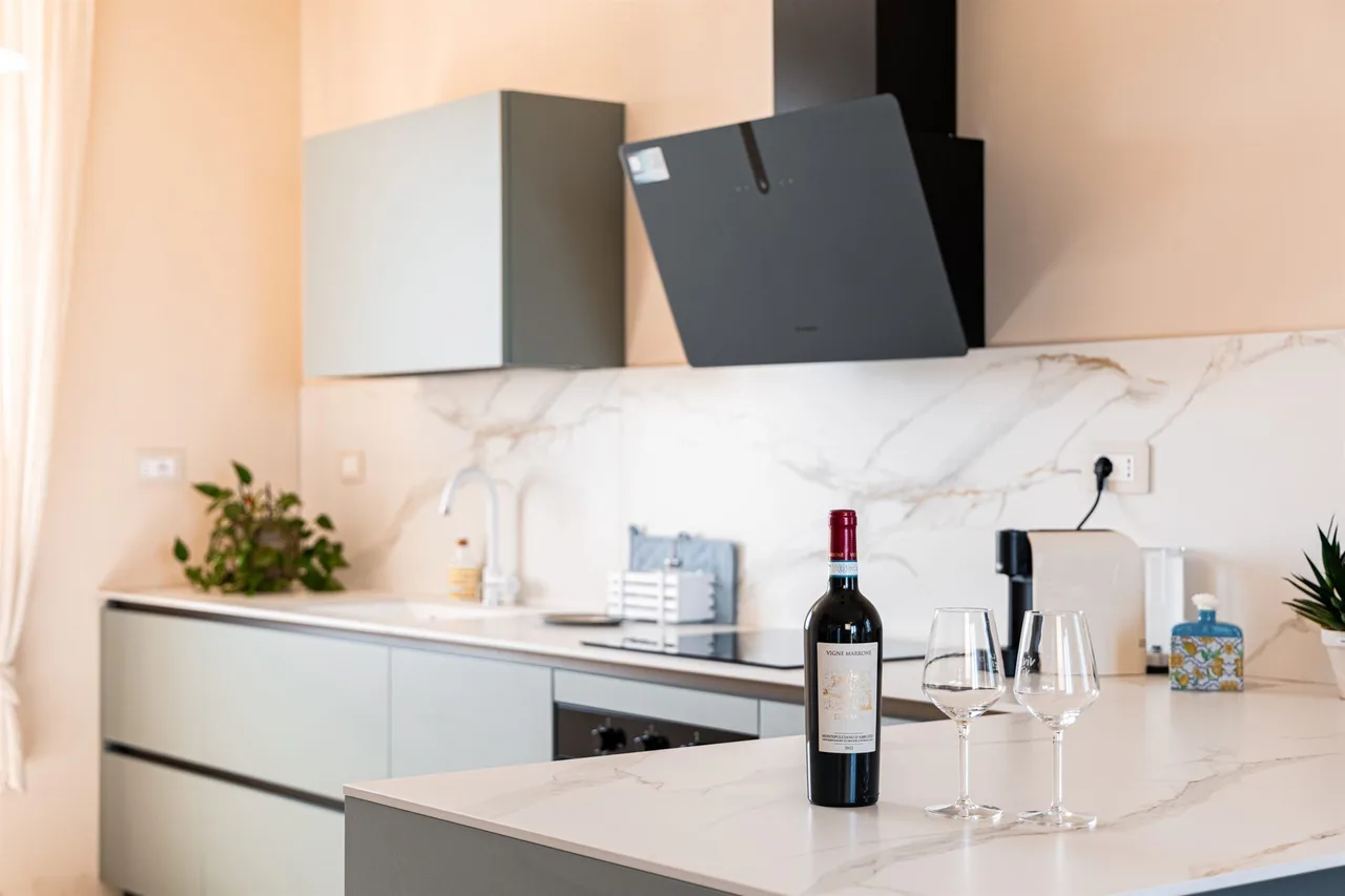 Cucina moderna con bottiglia e calici sul piano